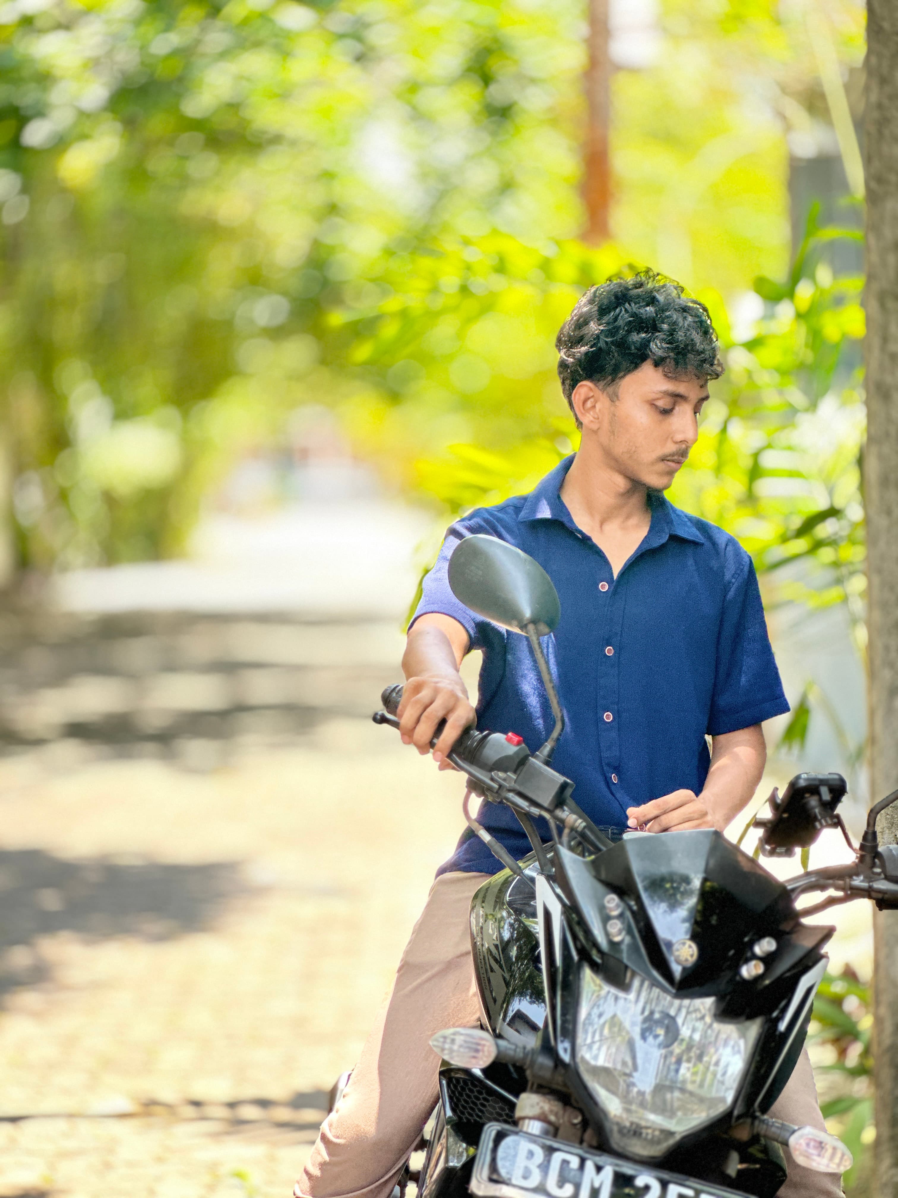 Vimukthi Indunil posing with a motorbike outdoors
