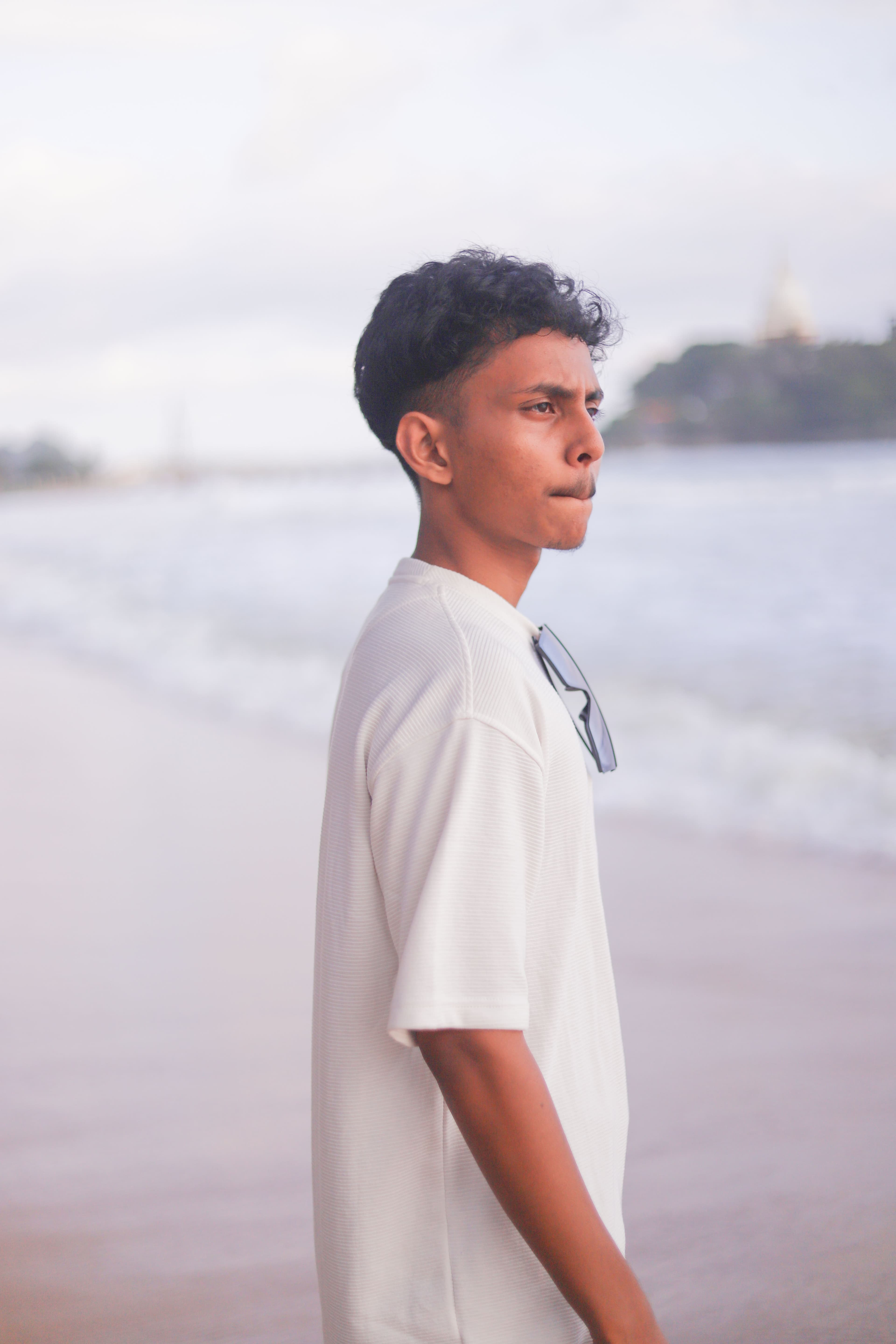 Vimukthi Indunil standing at the beach in a side-profile portrait