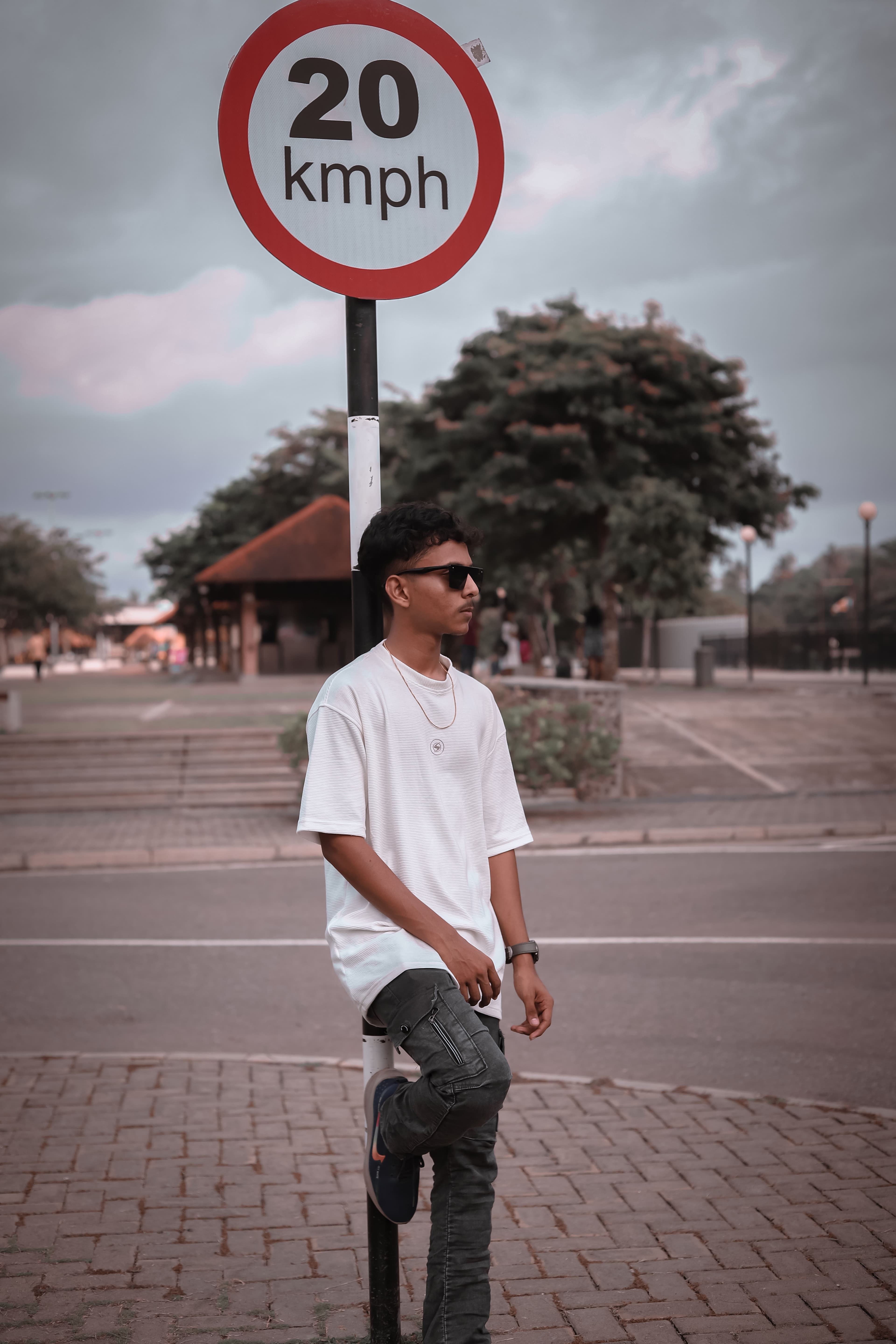 Vimukthi Indunil standing near a road sign in an urban outdoor setting